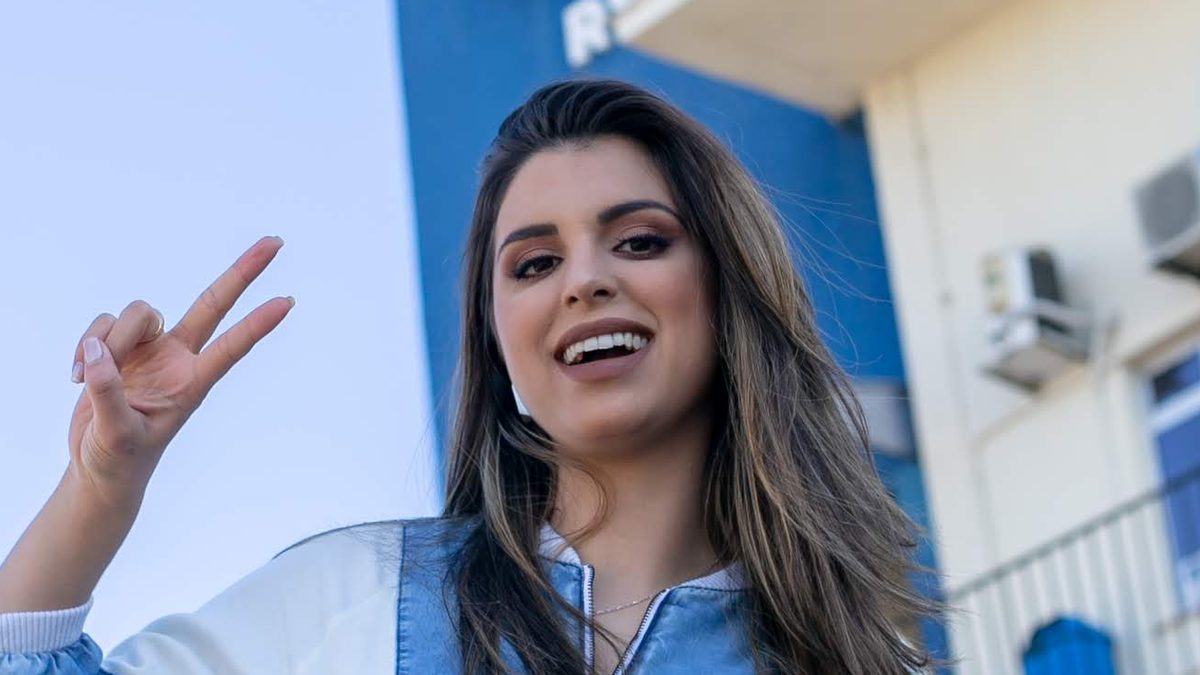 Mônica Fonseca, hoje participante de A Fazenda 18, sorri e faz o sinal de paz com a mão em foto de 2018 em Porto Alegre