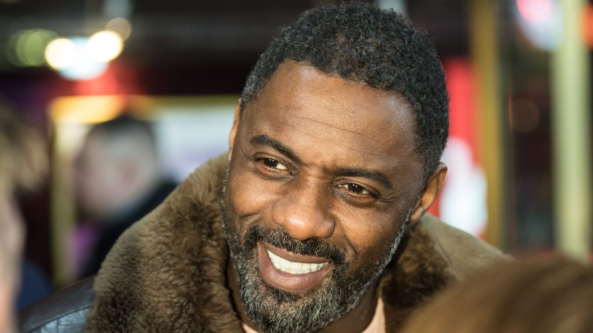 O ator Idris Elba, protagonista de A Fera, sorri de casaco com gola de pele no Festival de Berlim de 2018