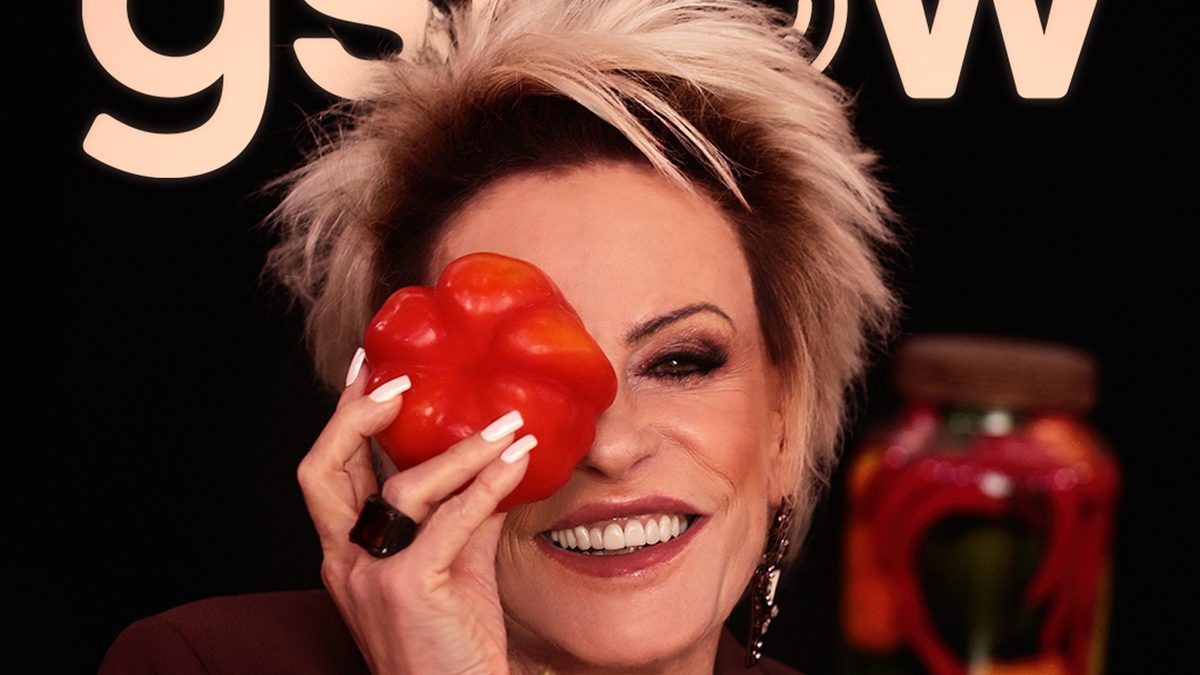 Ana Maria Braga sorri com um pimentão vermelho diante de um olho, na capa digital de outubro do gshow