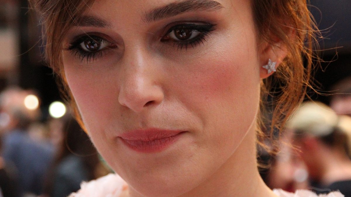 Close do rosto da atriz Keira Knightley, de cabelo preso e brinco de estrela, na estreia de Anna Karenina em Londres, em 2012