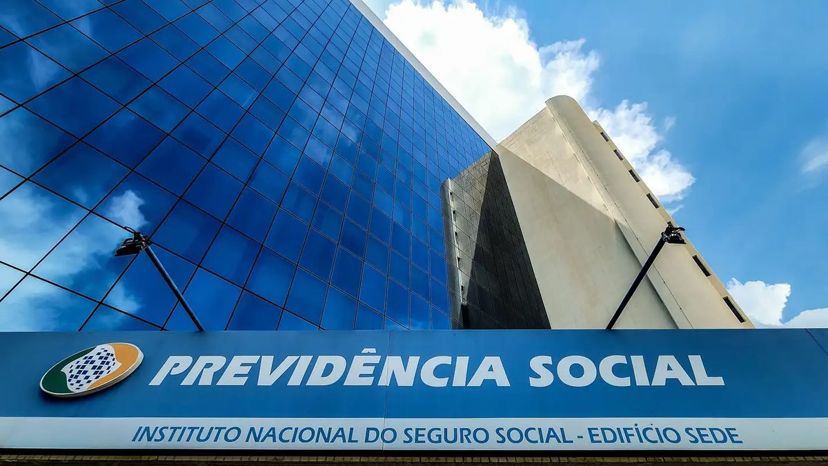 Fachada de vidro da sede do INSS em Brasília, com a placa Previdência Social e Instituto Nacional do Seguro Social