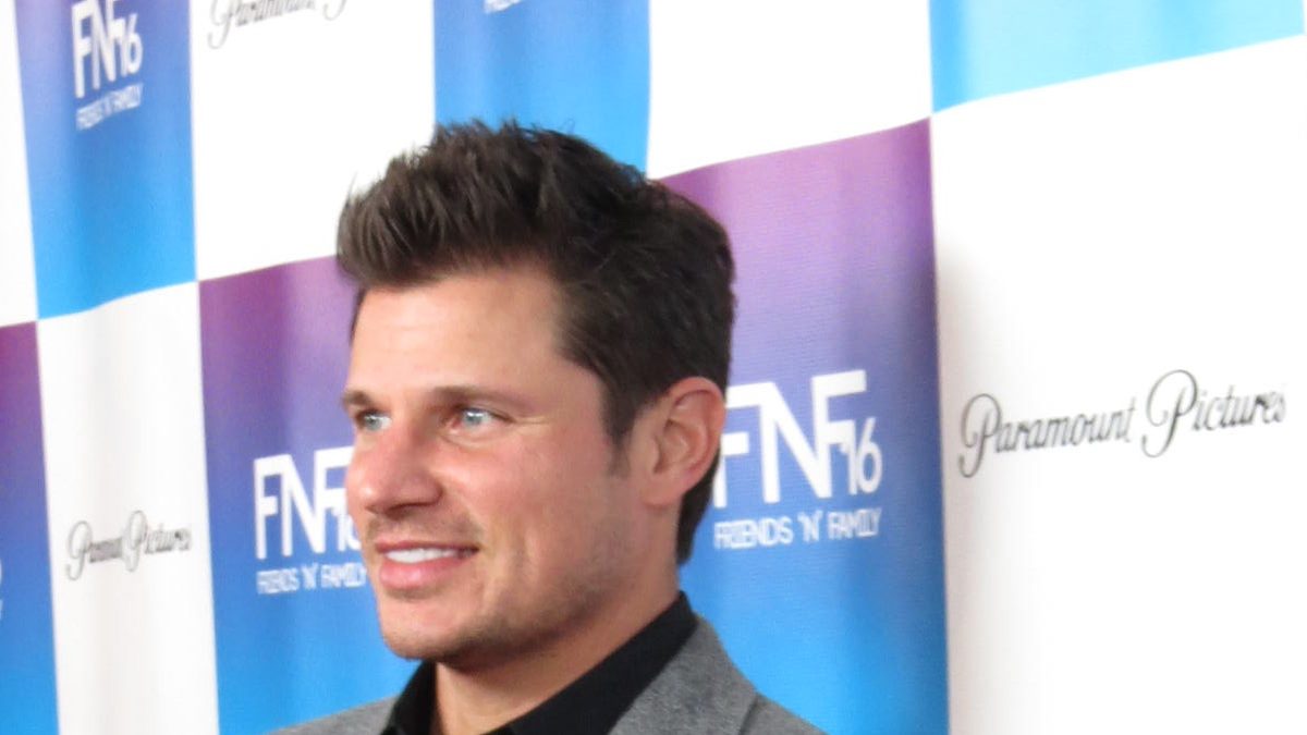 Nick Lachey, que apresenta Casamento às Cegas com Vanessa Lachey, sorri de blazer cinza num evento de 2013
