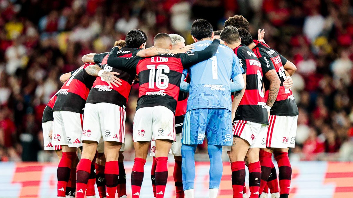Jogadores do Flamengo reunidos em roda no gramado do Maracanã, com a torcida ao fundo, em jogo do Brasileirão contra o Mirassol em 2 de setembro