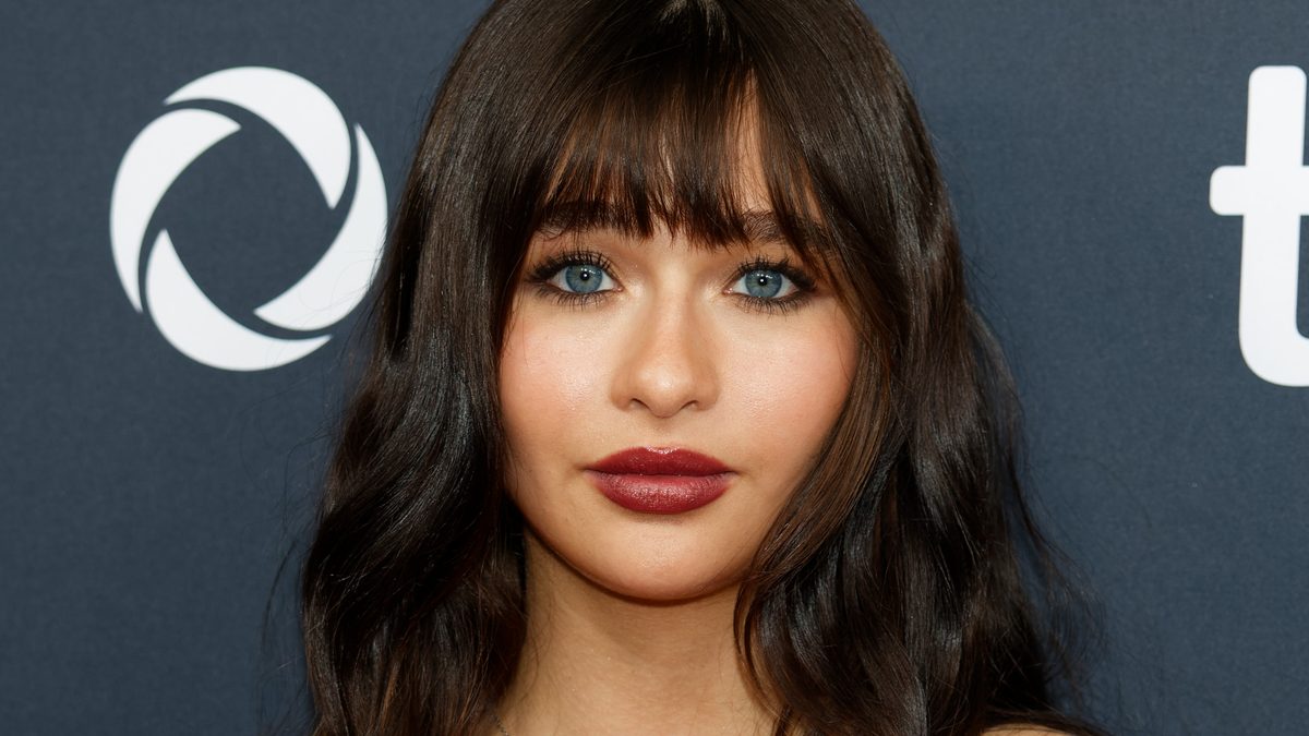 A atriz Malina Pauli Weissman, protagonista de Coven Academy, de franja e vestido vermelho no Festival de Toronto de 2024