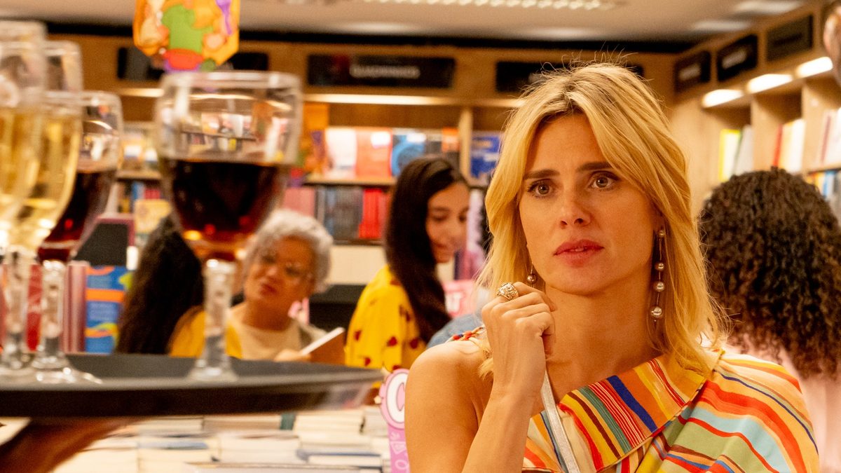 Carolina Dieckmann como a escritora Kátia Klein, numa livraria, olha para uma bandeja de taças de vinho em foto de divulgação do filme (Des)Controle