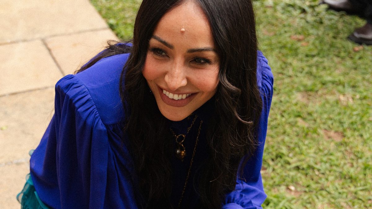 Sabrina Sato sorri agachada nas gravações de Dog House Brasil, em São Paulo, em foto de divulgação do GNT