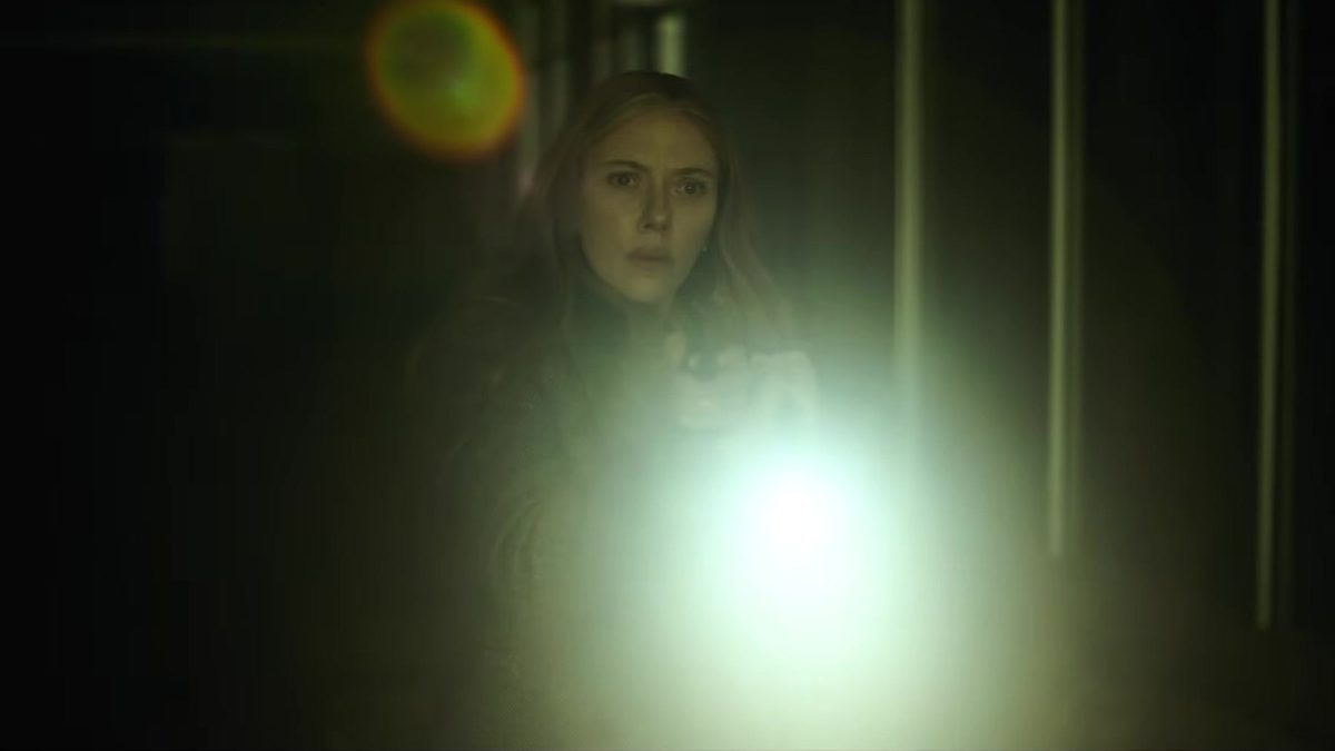Mulher assustada aponta uma lanterna em corredor escuro, em cena do teaser de O Exorcista: Mártires