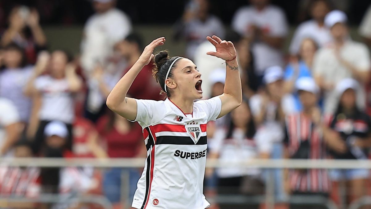 Jogadora do São Paulo, de camisa branca com listras tricolores, comemora com os braços para o alto no MorumBIS, na final do Brasileirão Feminino