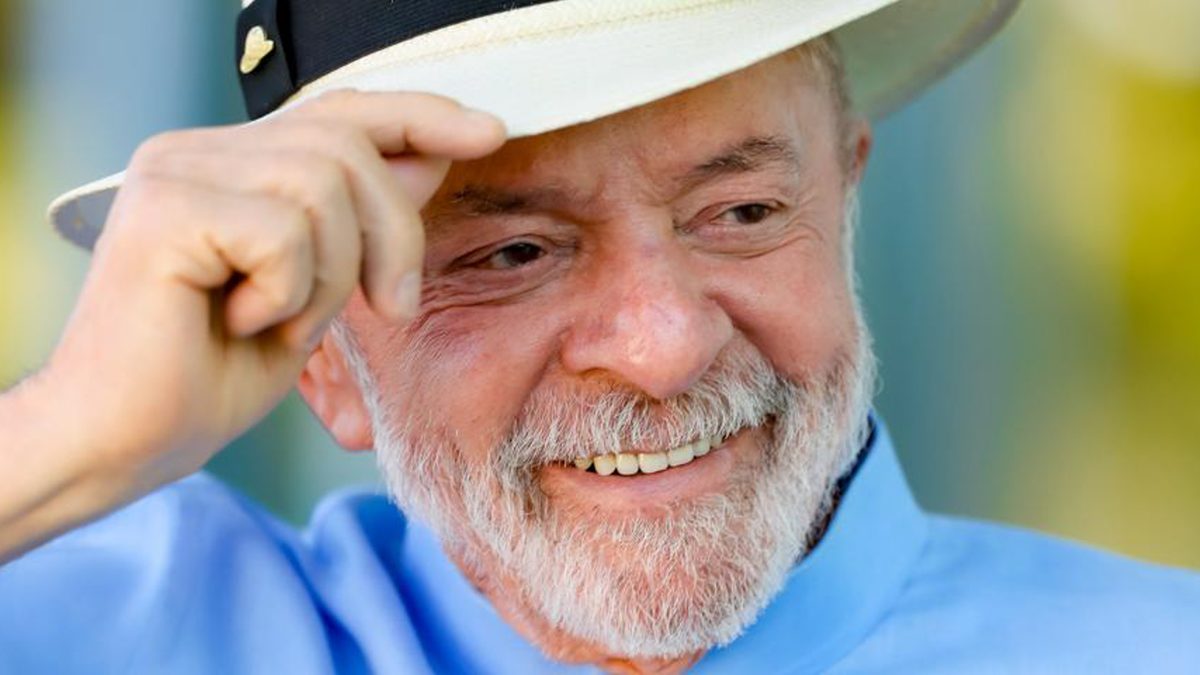 O presidente Lula sorri e segura a aba de um chapéu panamá branco, de camisa azul, em foto de 9 de julho de 2026 no Palácio da Alvorada
