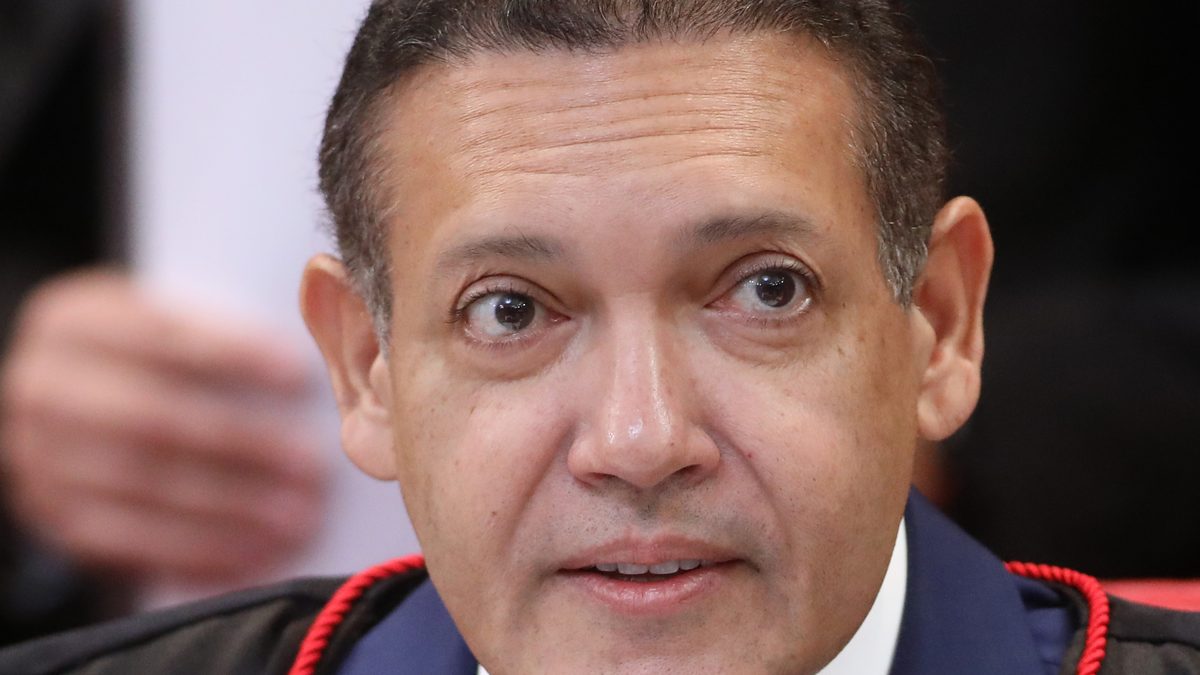 O ministro Kassio Nunes Marques, de toga azul e preta, fala ao microfone em sessão plenária do Tribunal Superior Eleitoral, em fevereiro de 2025
