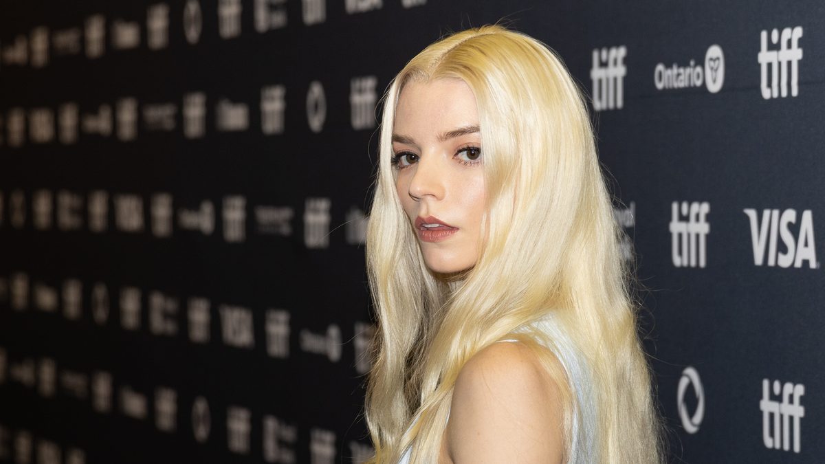 A atriz Anya Taylor-Joy, de cabelo loiro platinado, olha por cima do ombro diante do painel do Festival de Toronto de 2025