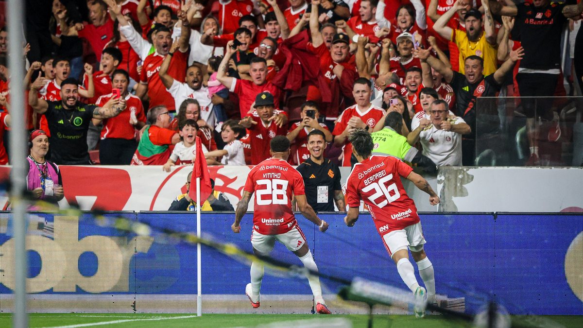 Dois jogadores do Internacional, de costas, comemoram diante da torcida no Beira-Rio, na vitória sobre o Corinthians pela 29ª rodada