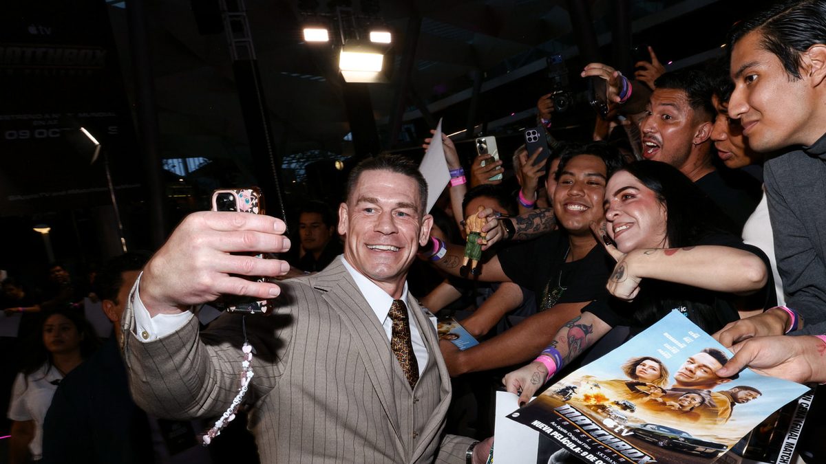 John Cena, de terno bege, tira uma selfie com fãs na sessão especial de Matchbox - O Filme, na Cidade do México