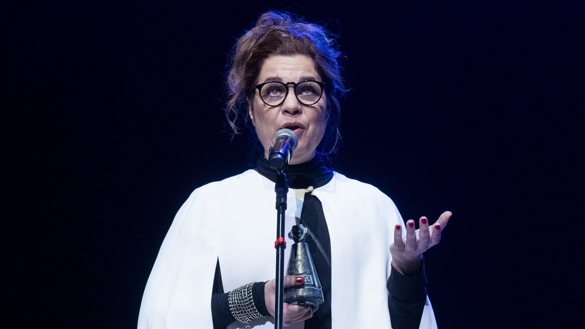 A atriz Isabel Teixeira, do elenco de Quem Ama Cuida, discursa ao microfone com o troféu nas mãos na 67ª edição do Prêmio APCA, no Teatro Sérgio Cardoso, em São Paulo, em julho de 2023