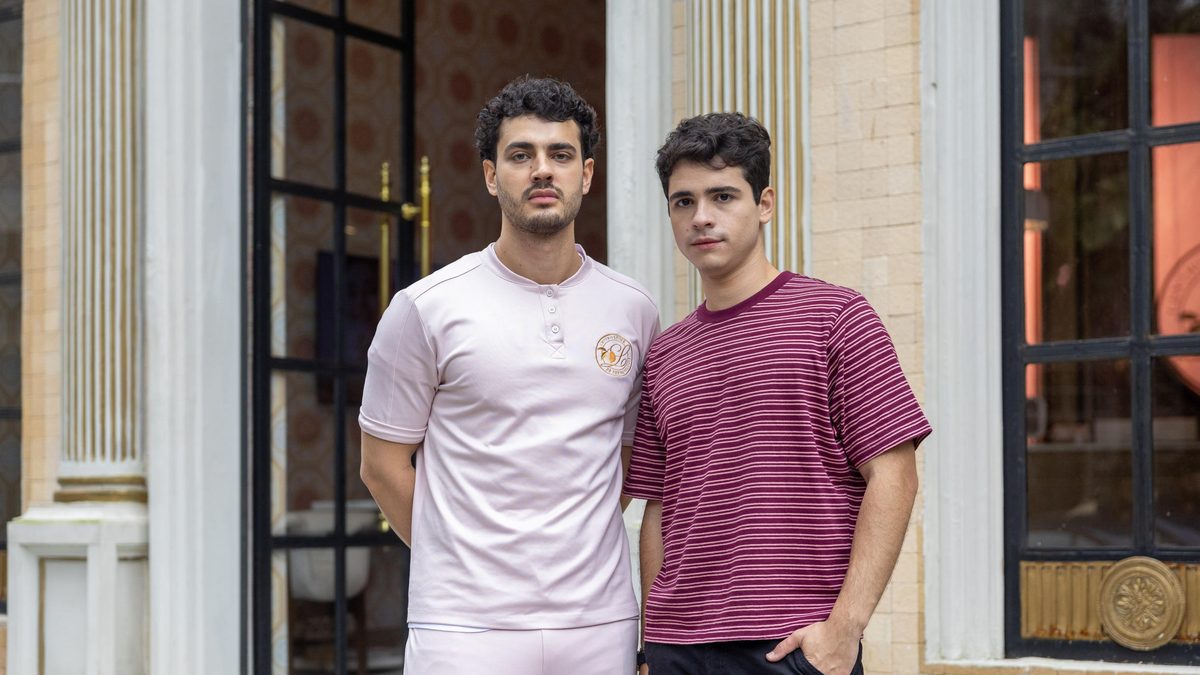 Dois personagens de Quem Ama Cuida diante da porta de uma casa, em foto de divulgação da Globo