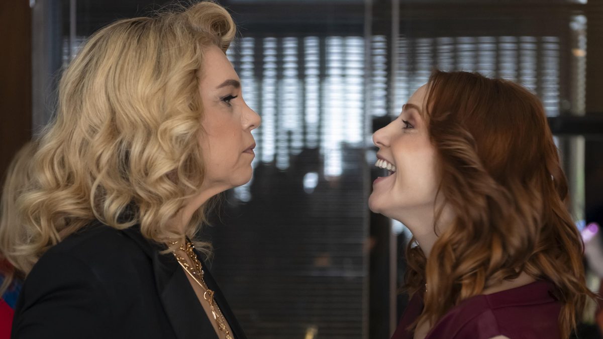Pilar, de cabelo loiro e blazer preto, e Adriana, de cabelo ruivo e blusa vinho, frente a frente em cena de Quem Ama Cuida