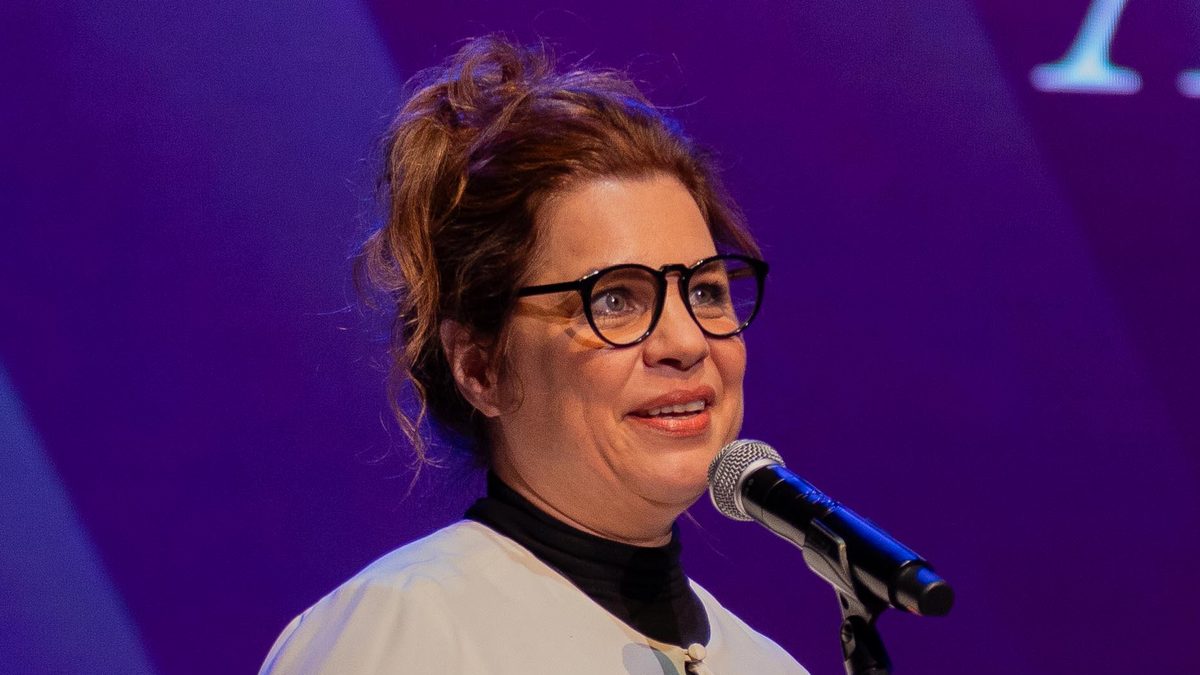 A atriz Isabel Teixeira, do elenco de Quem Ama Cuida, discursa ao microfone com o troféu nas mãos na 67ª edição do Prêmio APCA, no Teatro Sérgio Cardoso, em São Paulo, em julho de 2023