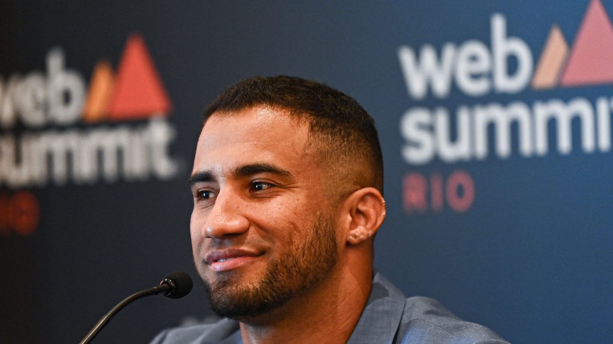 O produtor e diretor Konrad Dantas, o KondZilla, sorri de paletó azul durante entrevista coletiva no Web Summit Rio, no Riocentro, no Rio de Janeiro, em maio de 2023