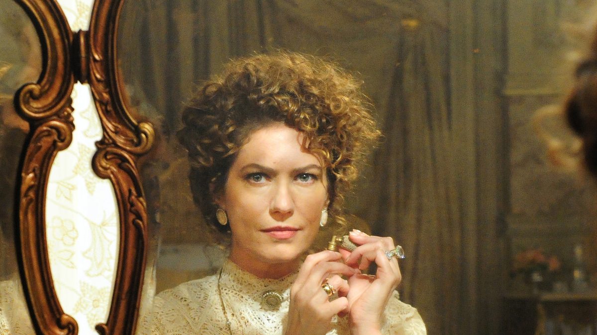 A atriz Patrícia Pillar, de cabelo cacheado e blusa de renda, refletida em um espelho de moldura dourada em foto de 2012
