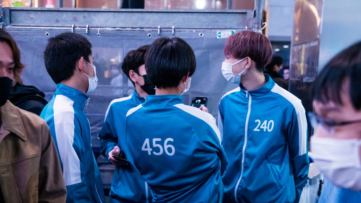 Fãs vestidos com o agasalho verde-azulado dos jogadores de Round 6, com os números 456 e 240 nas costas, no Halloween de Shibuya, em Tóquio, em 2021