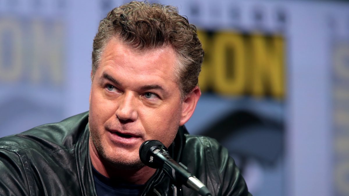 O ator Eric Dane, de jaqueta de couro preta, fala ao microfone num painel da Comic-Con de San Diego em 2017
