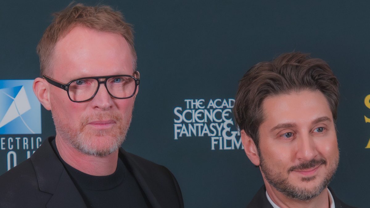 O ator Paul Bettany, de óculos e terno preto, ao lado do roteirista e diretor Terry Matalas no Saturn Awards de 2026